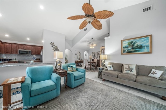 living room with arched walkways, marble finish floor, visible vents, and ceiling fan