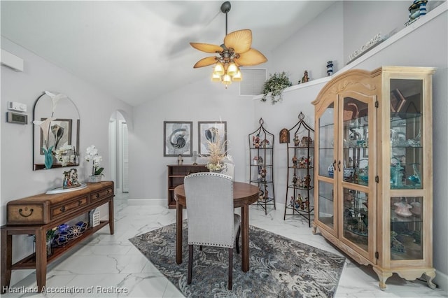 dining space featuring lofted ceiling, marble finish floor, ceiling fan, and arched walkways