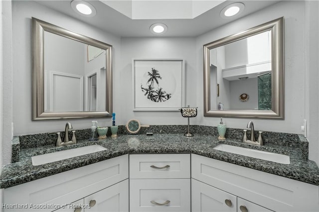 bathroom featuring double vanity, a sink, and recessed lighting