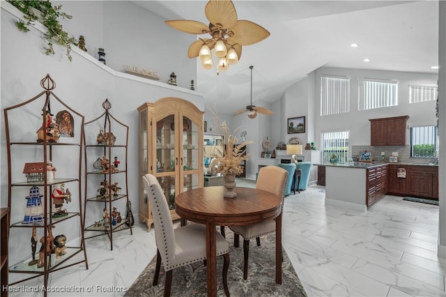 dining room featuring ceiling fan, marble finish floor, high vaulted ceiling, and recessed lighting