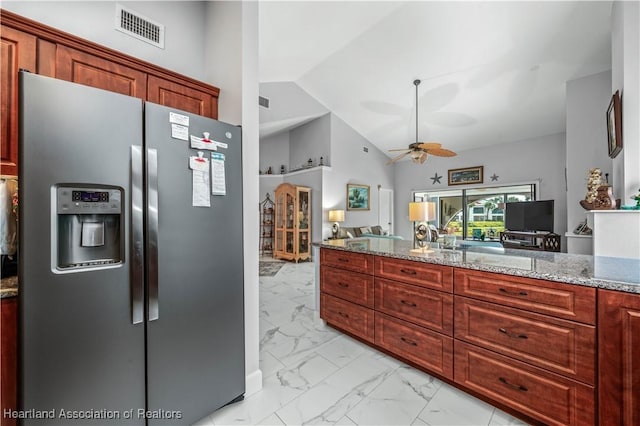 kitchen with light stone counters, marble finish floor, visible vents, vaulted ceiling, and stainless steel fridge