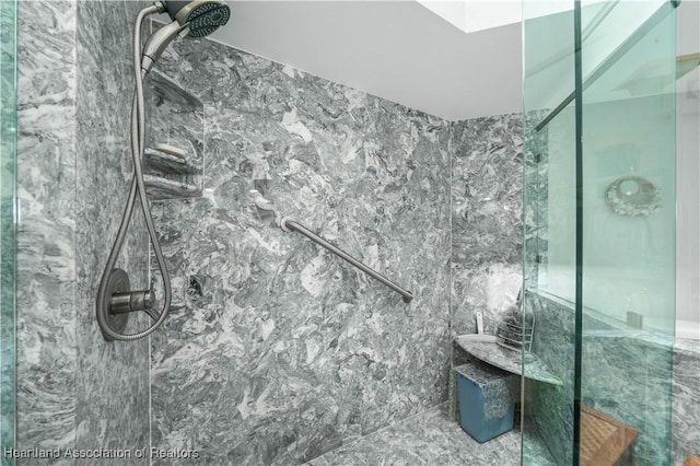 bathroom with a marble finish shower