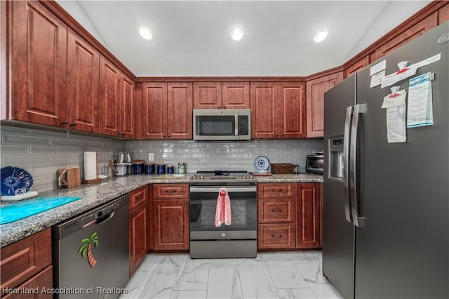 kitchen featuring lofted ceiling, marble finish floor, appliances with stainless steel finishes, and tasteful backsplash