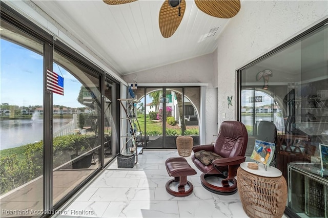 sunroom with lofted ceiling and a water view