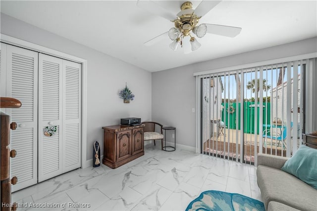 office space with marble finish floor, ceiling fan, and baseboards