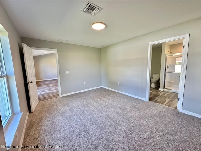 unfurnished bedroom with carpet flooring and ensuite bathroom