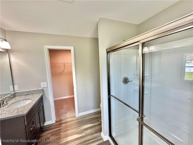 bathroom with vanity, a shower with shower door, and hardwood / wood-style flooring