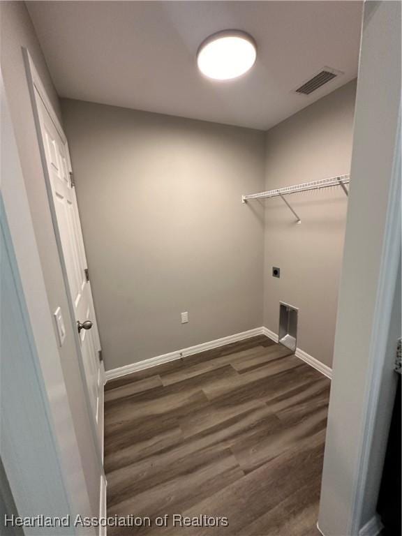 clothes washing area featuring dark hardwood / wood-style flooring and electric dryer hookup