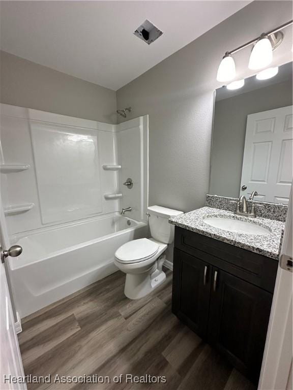 full bathroom featuring wood-type flooring, vanity, toilet, and tub / shower combination