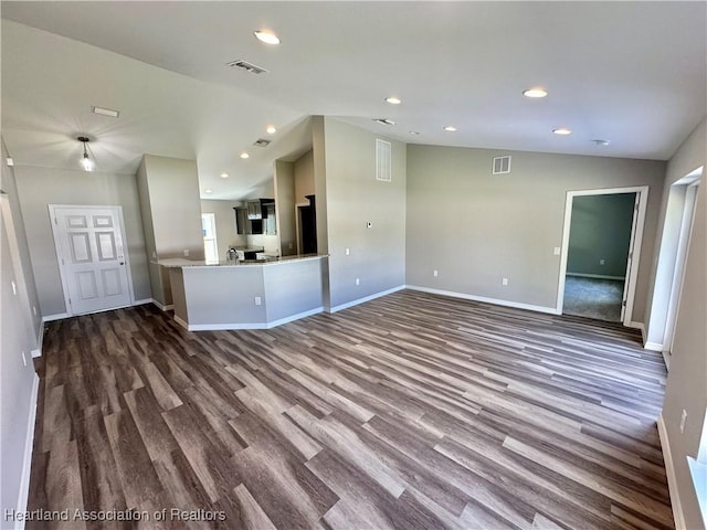 unfurnished living room featuring hardwood / wood-style flooring and vaulted ceiling