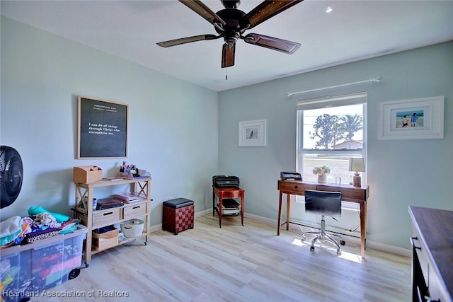 office space featuring baseboards, ceiling fan, and wood finished floors