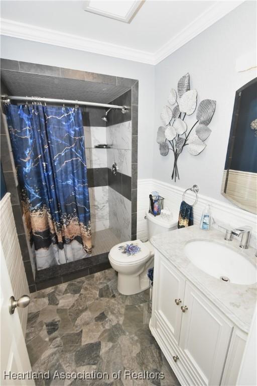 full bath with vanity, ornamental molding, a shower stall, and toilet