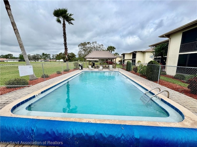 community pool featuring a gazebo and fence