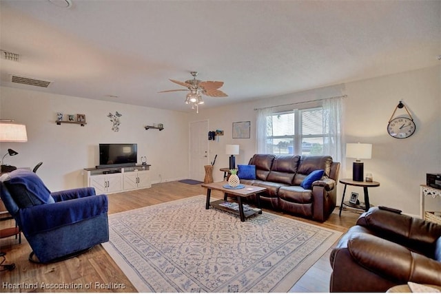 living room with light wood-type flooring and ceiling fan