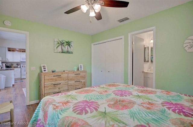 bedroom featuring hardwood / wood-style flooring, ceiling fan, a closet, and ensuite bath