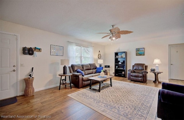 living room featuring ceiling fan, a textured ceiling, and hardwood / wood-style flooring