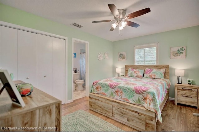 bedroom with ensuite bath, ceiling fan, a closet, and light wood-type flooring