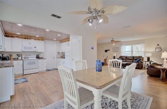 dining space featuring light hardwood / wood-style flooring, ceiling fan, and sink