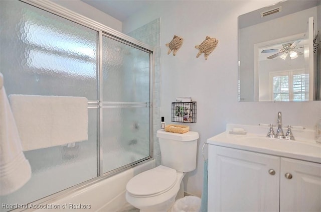 full bathroom featuring vanity, toilet, ceiling fan, and bath / shower combo with glass door