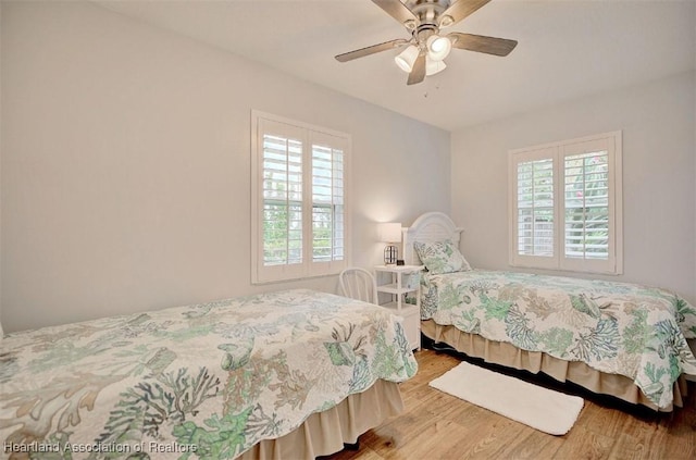 bedroom featuring multiple windows, ceiling fan, and light hardwood / wood-style floors