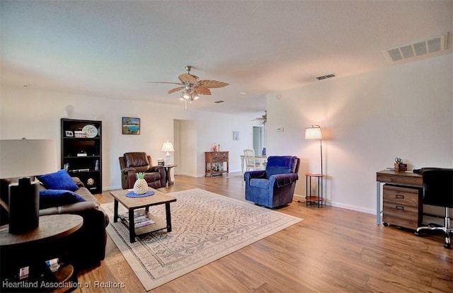 living room featuring wood-type flooring and ceiling fan