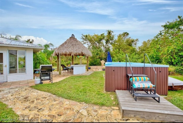 view of yard with a gazebo, an outdoor bar, a hot tub, and a patio