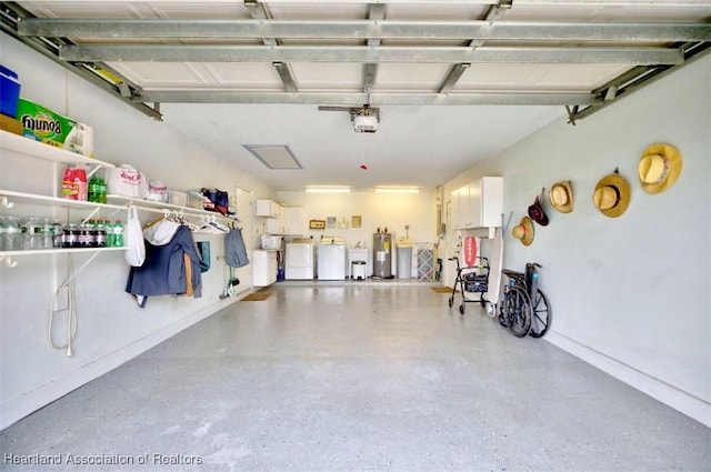 garage with electric water heater, a garage door opener, and washing machine and clothes dryer