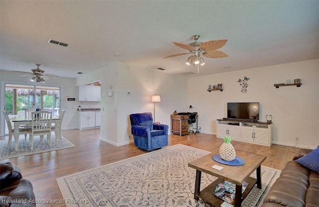 living room with light wood-type flooring and ceiling fan