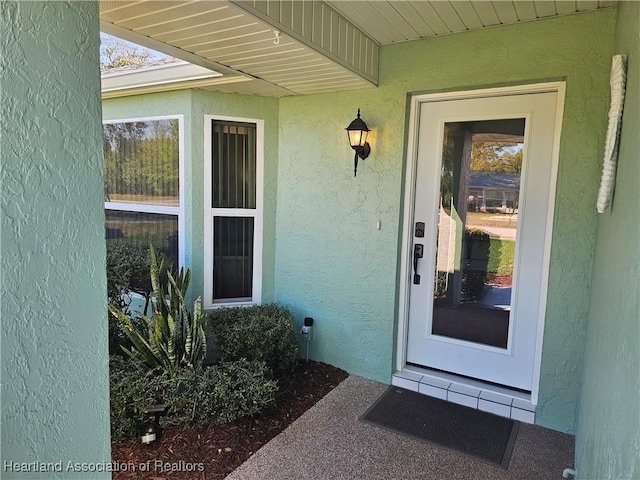 entrance to property featuring stucco siding