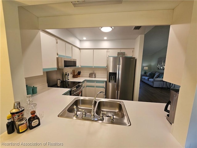 kitchen featuring visible vents, a sink, appliances with stainless steel finishes, white cabinets, and light countertops