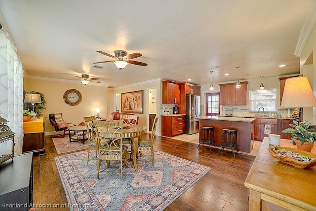 dining room featuring ornamental molding, a ceiling fan, wood finished floors, recessed lighting, and baseboards