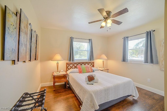 bedroom featuring multiple windows, wood finished floors, and baseboards