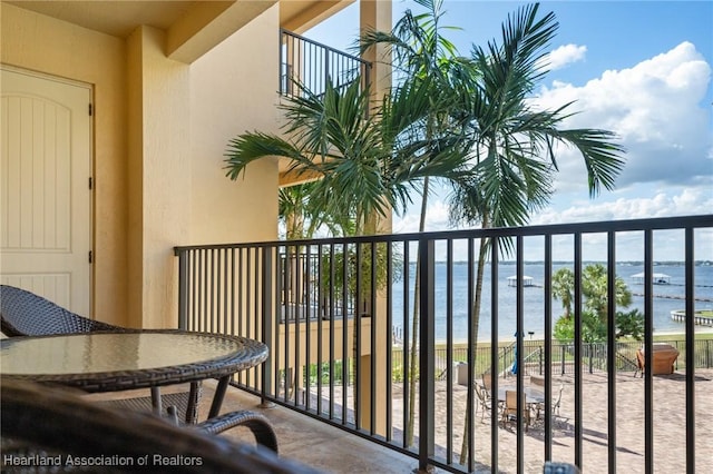 balcony with a water view and a view of the beach