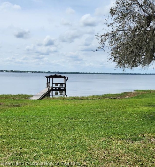 dock area with a yard and a water view