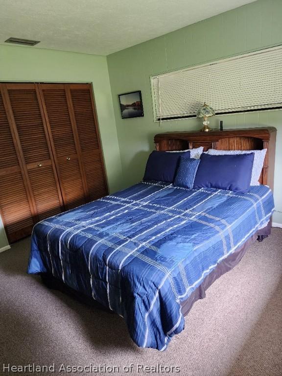 carpeted bedroom featuring a closet and a textured ceiling