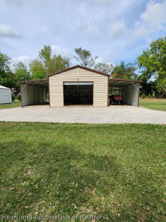 garage featuring a yard and a carport