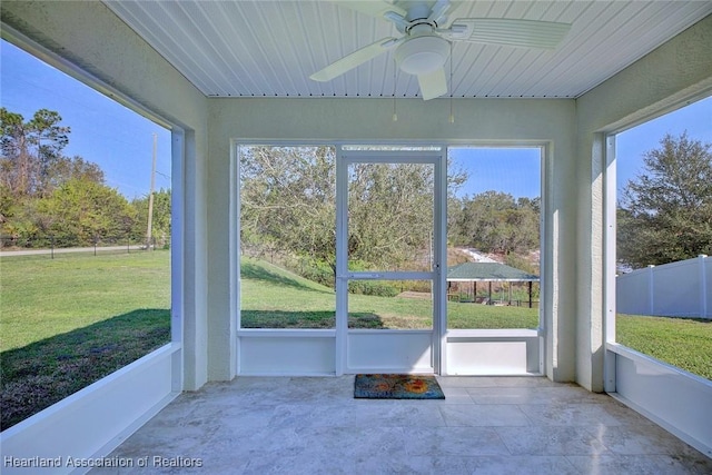 unfurnished sunroom featuring ceiling fan