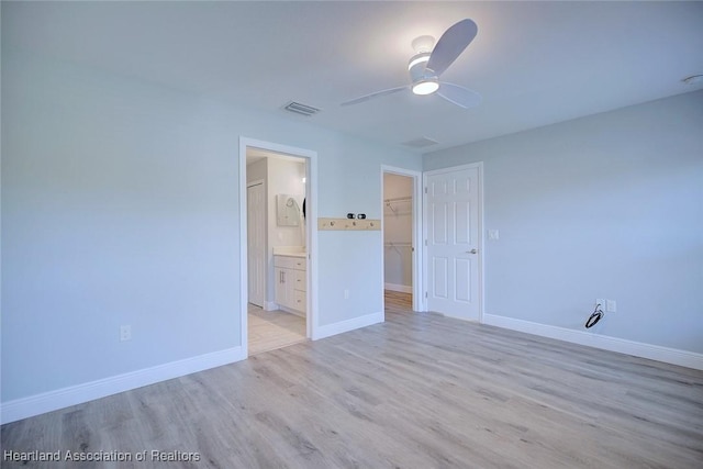 empty room with ceiling fan and light wood-type flooring