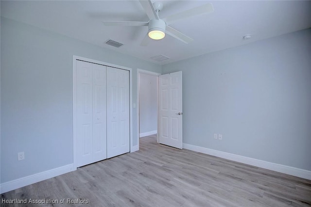 unfurnished bedroom with ceiling fan, light wood-type flooring, and a closet