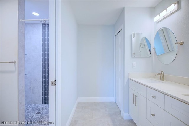 bathroom with vanity and a tile shower