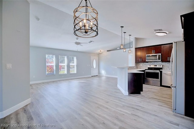 kitchen featuring ceiling fan with notable chandelier, appliances with stainless steel finishes, dark brown cabinets, and pendant lighting