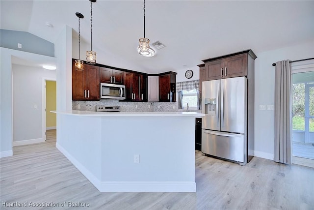 kitchen with stainless steel appliances, plenty of natural light, pendant lighting, and dark brown cabinetry