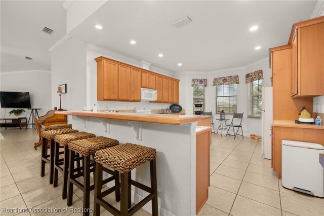3038 Cedora Ter, Sebring, FL 33870 - kitchen featuring white appliances, ornamental molding, light tile patterned floors, a peninsula, and light countertops