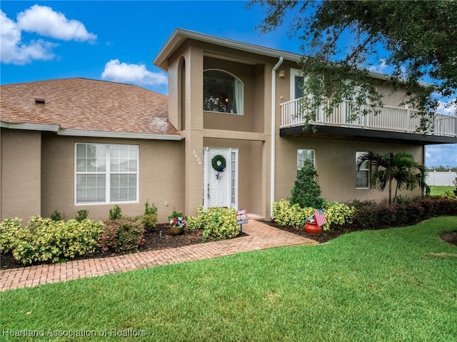 3038 Cedora Ter, Sebring, FL 33870 - view of front facade with a balcony, stucco siding, and a front lawn