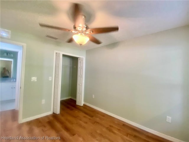 unfurnished bedroom featuring hardwood / wood-style flooring, ceiling fan, and a closet