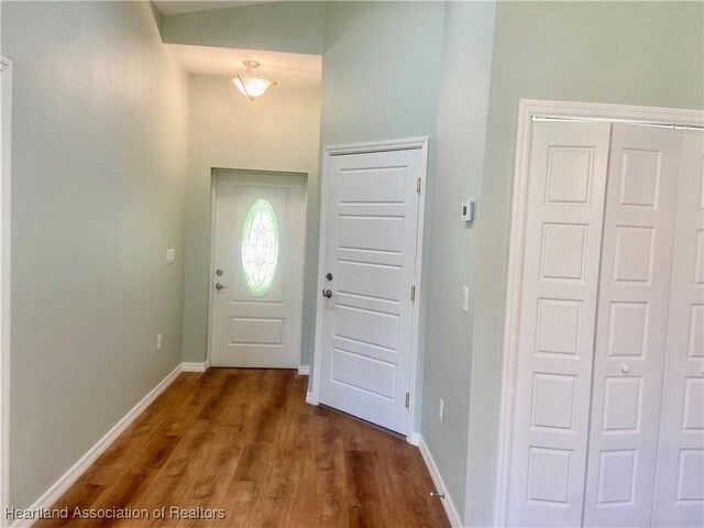 entrance foyer featuring dark hardwood / wood-style floors and vaulted ceiling