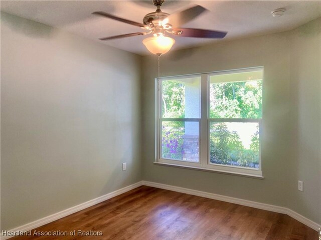 empty room with hardwood / wood-style floors and ceiling fan