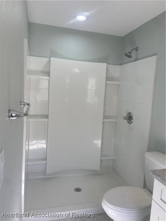 bathroom with toilet, walk in shower, and vanity