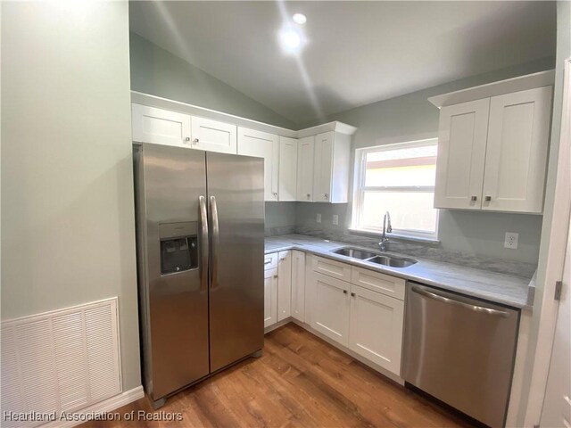 kitchen featuring white cabinets, hardwood / wood-style flooring, sink, and appliances with stainless steel finishes