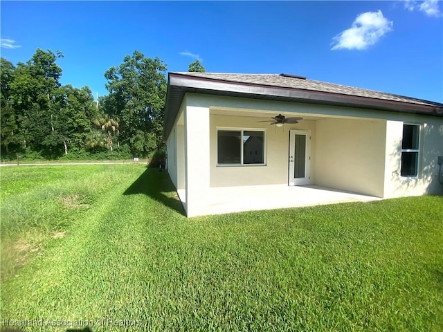 back of house featuring a patio area, ceiling fan, a yard, and stucco siding